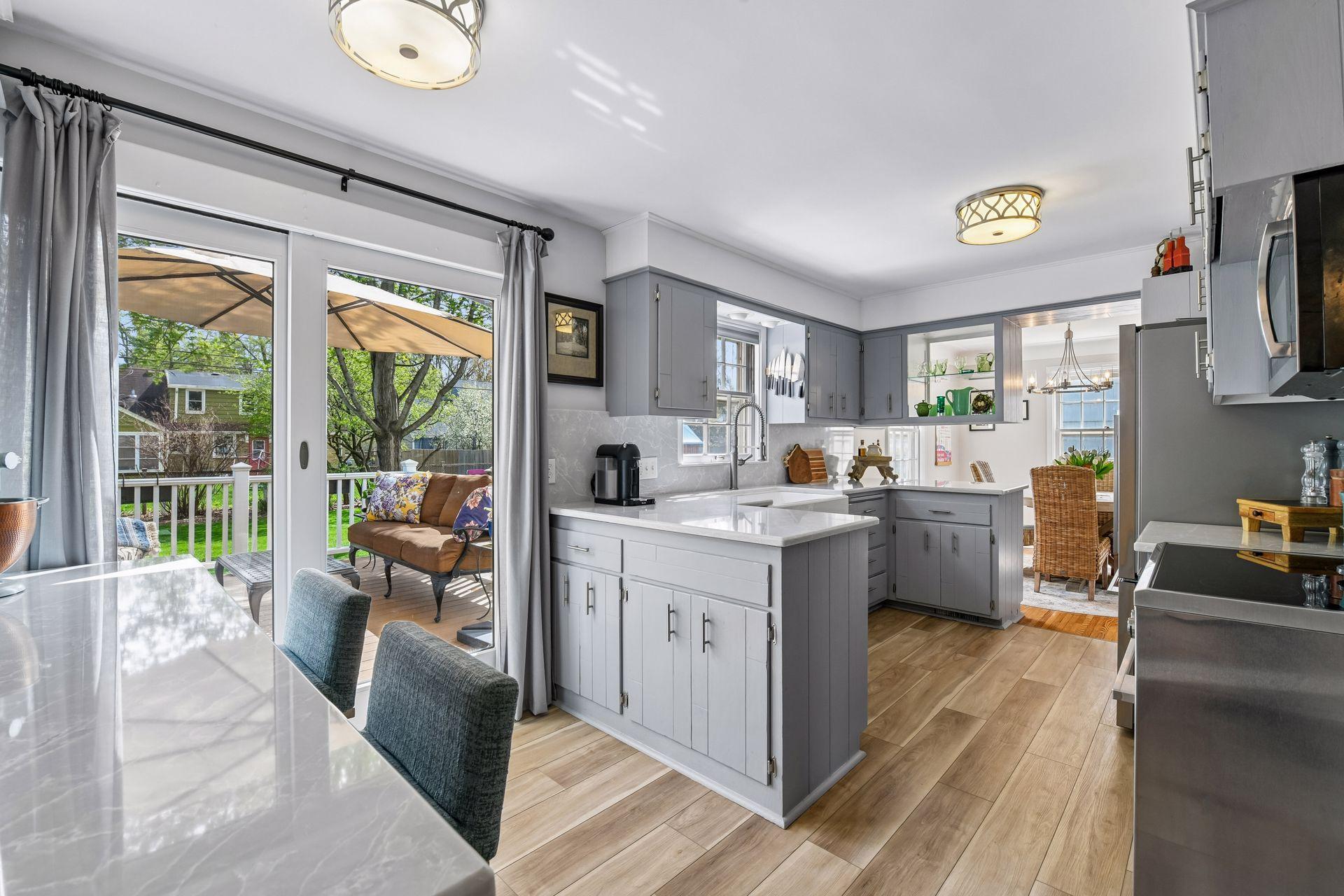 The updated eat-in kitchen showcases new quartz countertops and backsplash, gourmet appliances, new LVP flooring, and freshly painted cabinetry, walls, and ceiling.