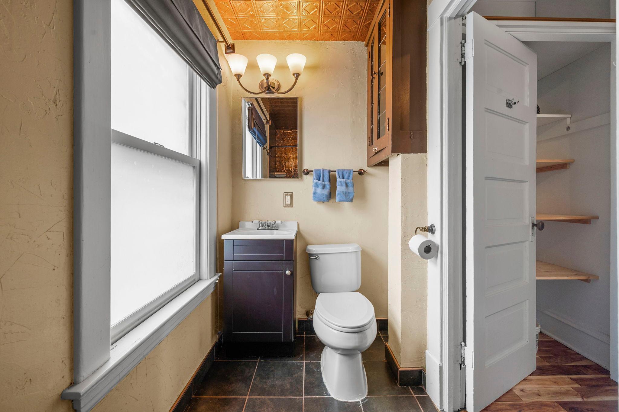 The full bathroom features a single vanity, tile flooring, and a tub/shower combination. Just outside the bathroom is a convenient, spacious linen closet.