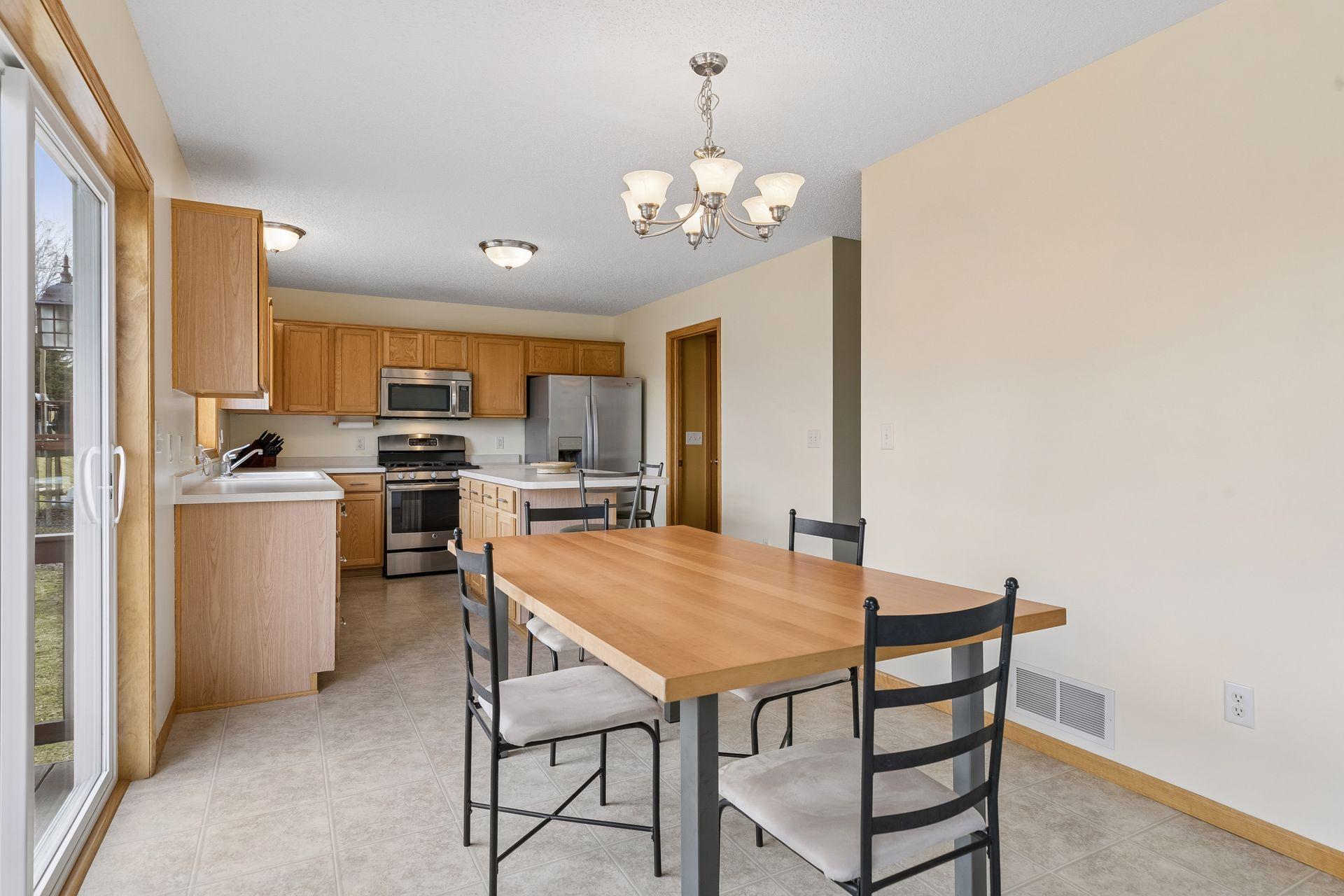 49 Windsor Wood Path - Dining room view into kitchen with stainless steel appliances and kitchen island with breakfast bar seating.