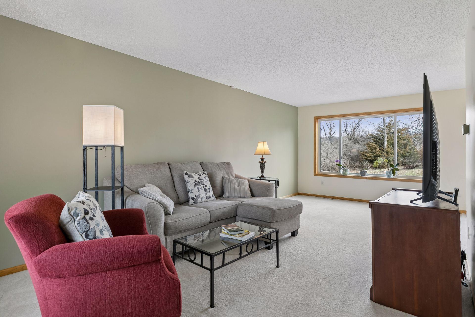 49 Windsor Wood Path - Living room features large new windows and a nearby dining room patio door allowing in natural light on both sides and a nice view of the nearly 1/2 acre lot.