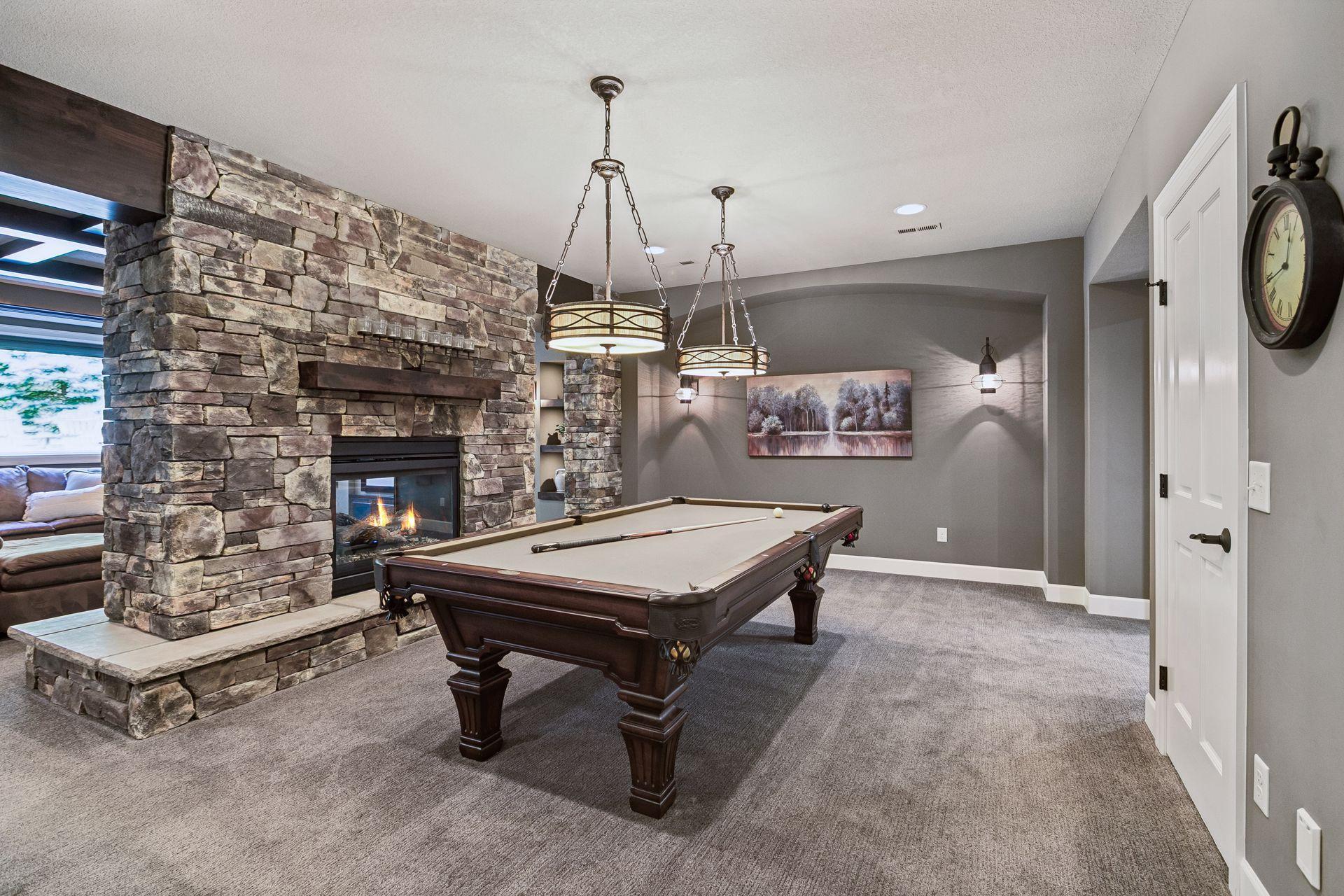Floating stone fireplace between game room & theater room