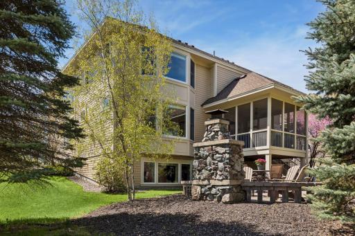 Enjoy the backyard from the screen porch or the patio with stone fireplace
