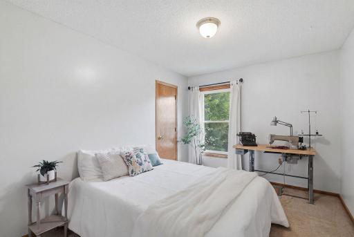 Upper-level bedroom #2 with bright window and neutral finishes