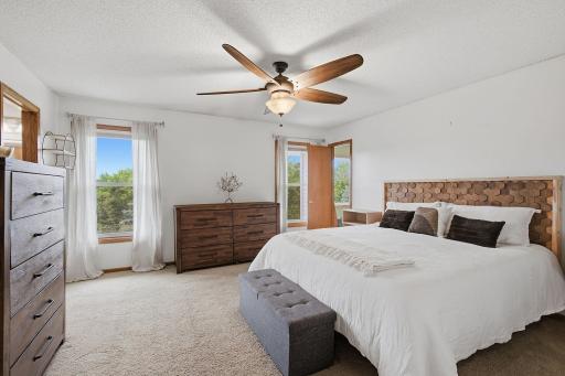Primary bedroom with ceiling fan, natural light, and comfortable layout