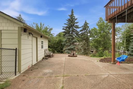 Patio area near the detached garage and backyard landscaping