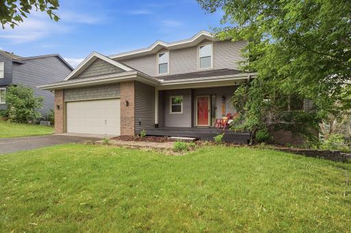 Front exterior with attached garage, covered porch, and established landscaping