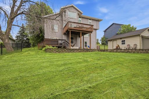 Rear exterior with spacious yard and multiple outdoor living areas