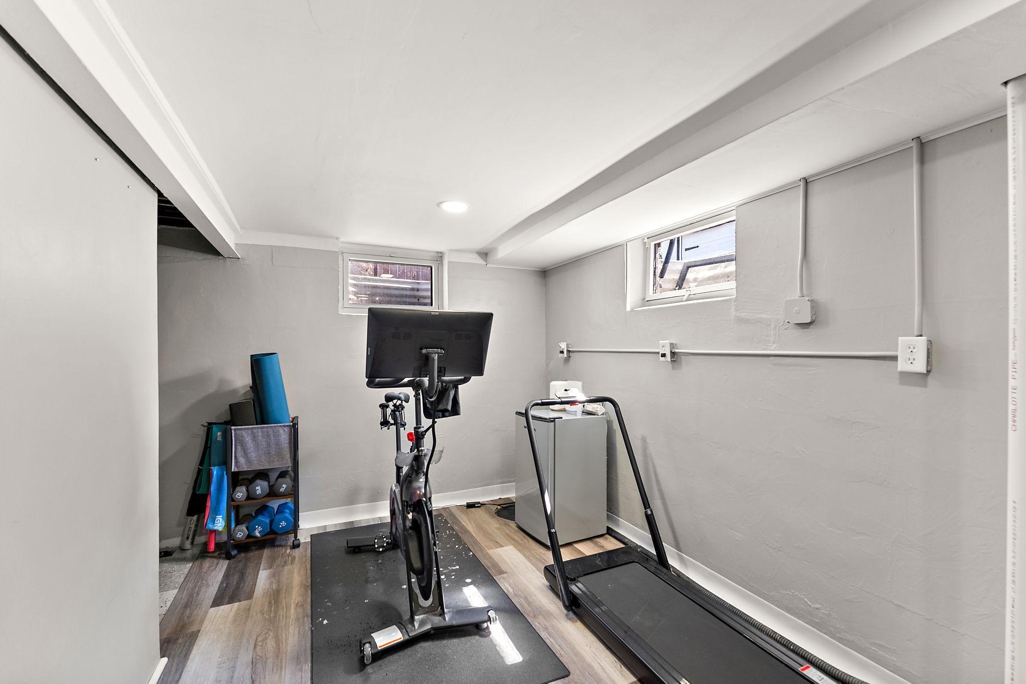 The lower level flex space in the corner beyond the bar can be used as gym, play area or office space depending on your needs.