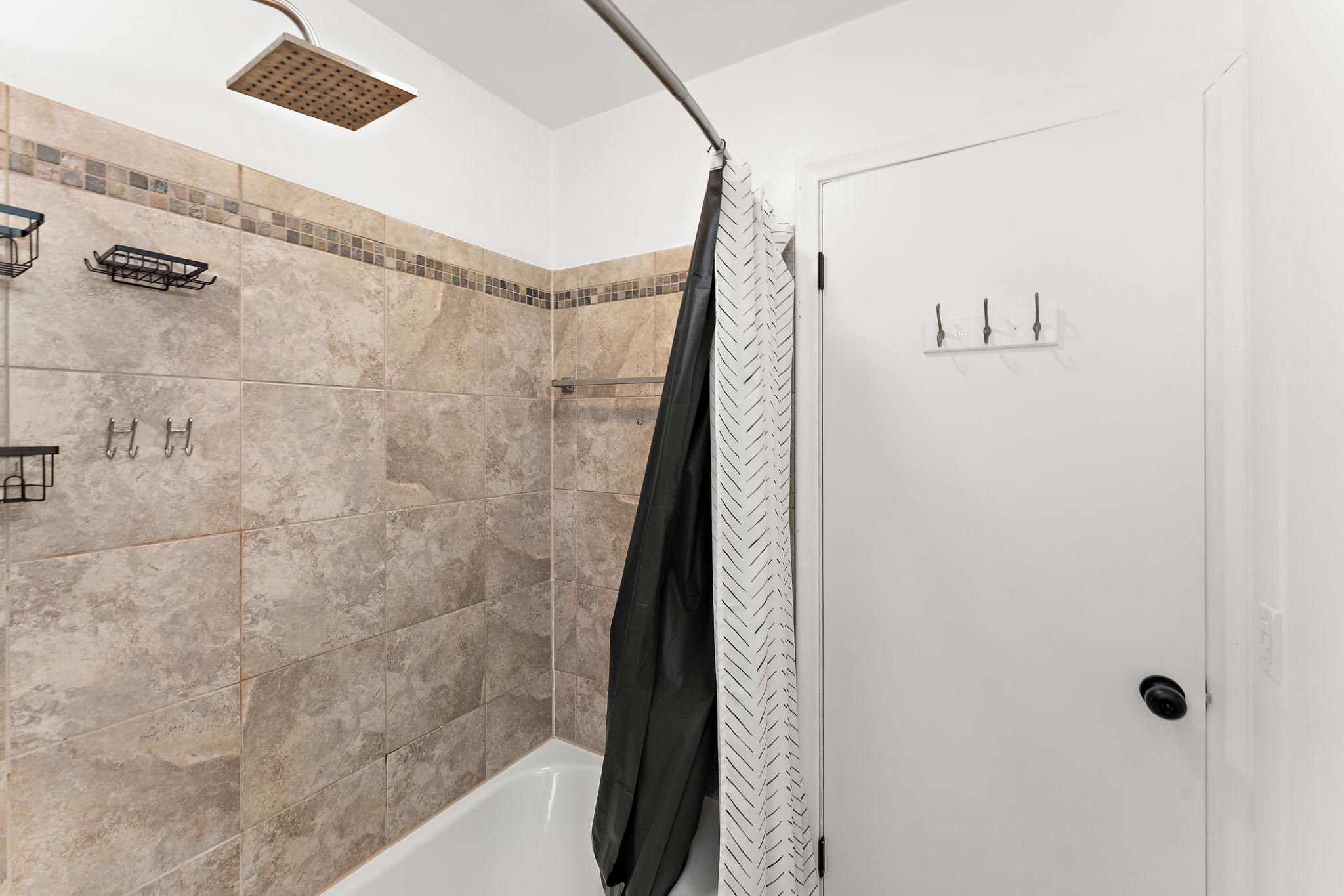 The main floor full bathroom has a tiled shower.