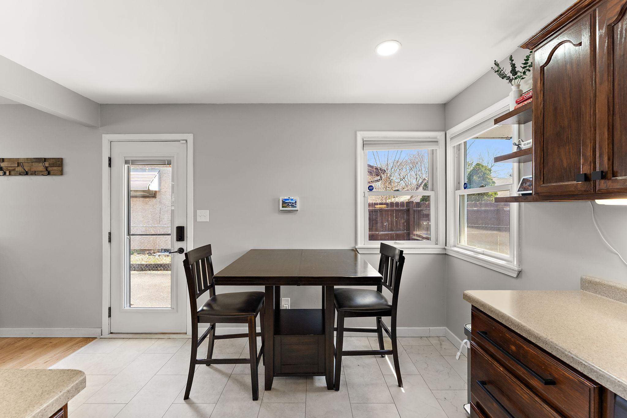 The dining area is tiled floor and has the side door leading to the outdoors and the front of the garage. There are plenty of windows allowing natural light to brighten up the informal dining area, making it a cheery space for morning coffee.