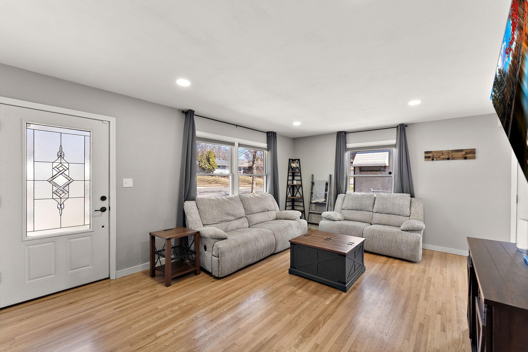 The front door is on the left and the living room has three large windows allowing natural light to flood the room making this a cozy place for relaxing.