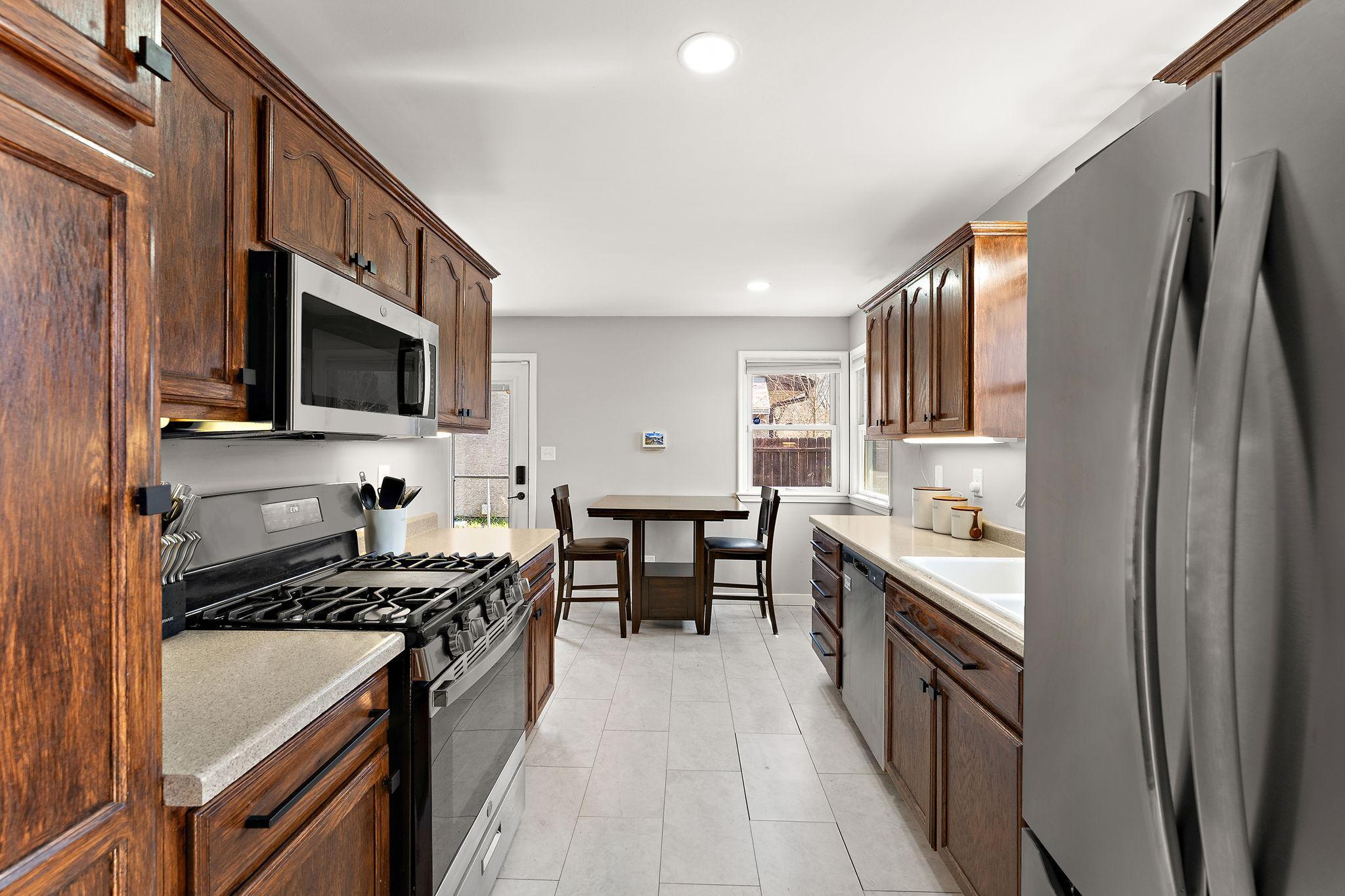 The kitchen features newly refinished cabinets and hardware, new stainless steel appliances replaced in August 2025: refrigerator, gas range and dishwasher.