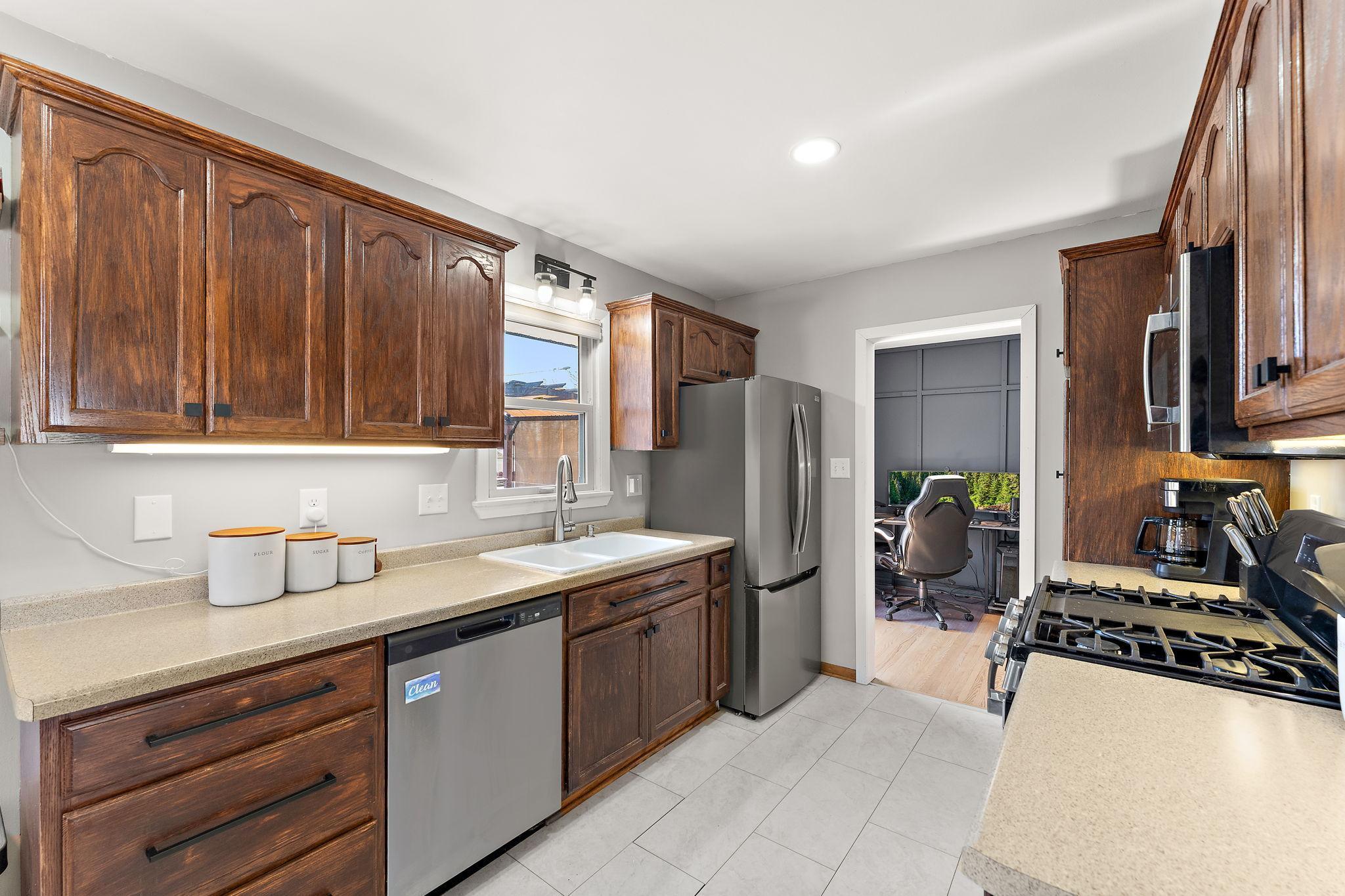 The kitchen has a window over the sink with a view of the backyard and has a new gas range and beautifully refinished cabinets with new hardware. The interior also features fresh paint.