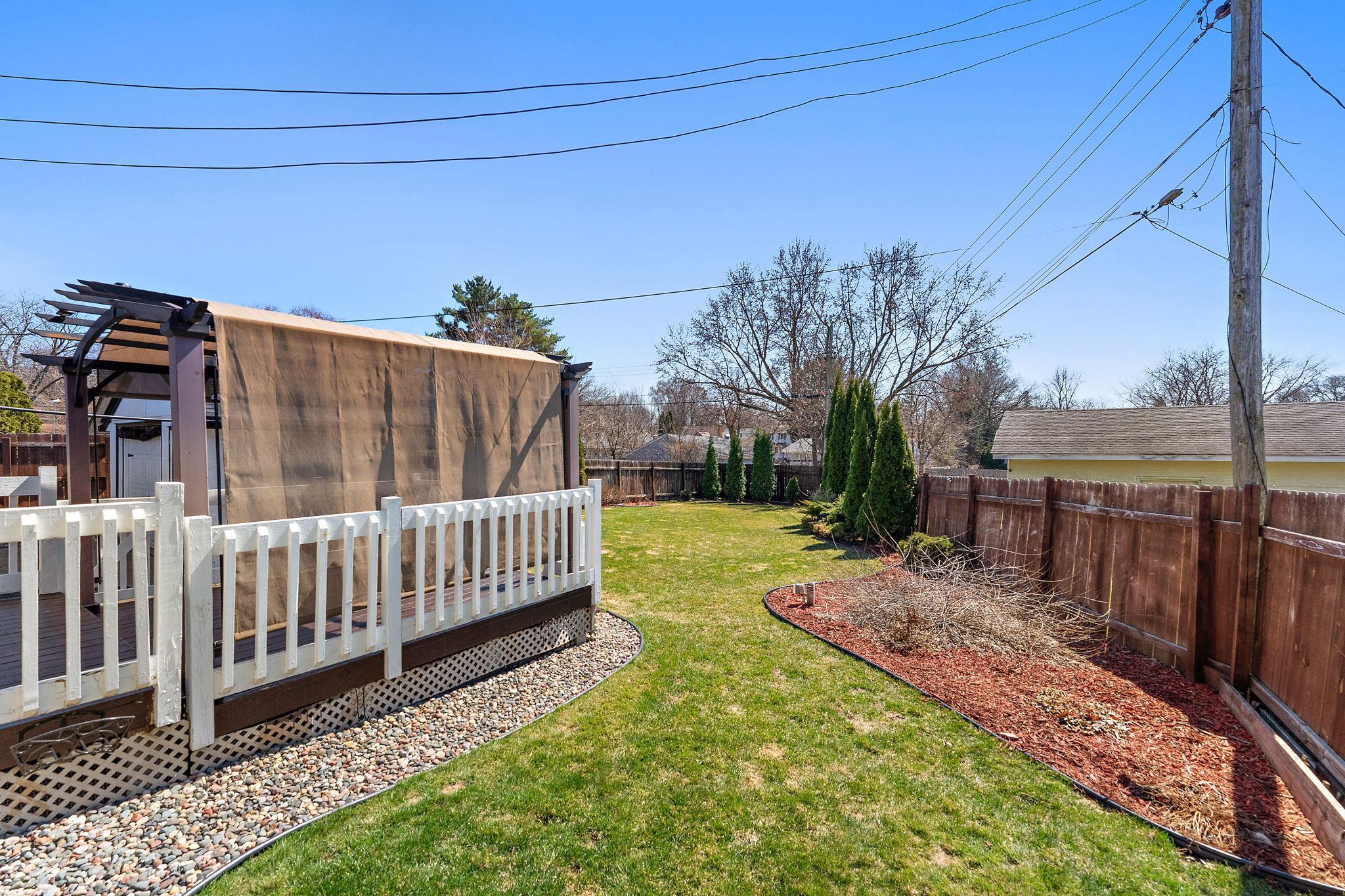 The backyard is a lovely green space with room for flower beds, gardening and outdoor yard games, all secure within a wooden privacy fence.
