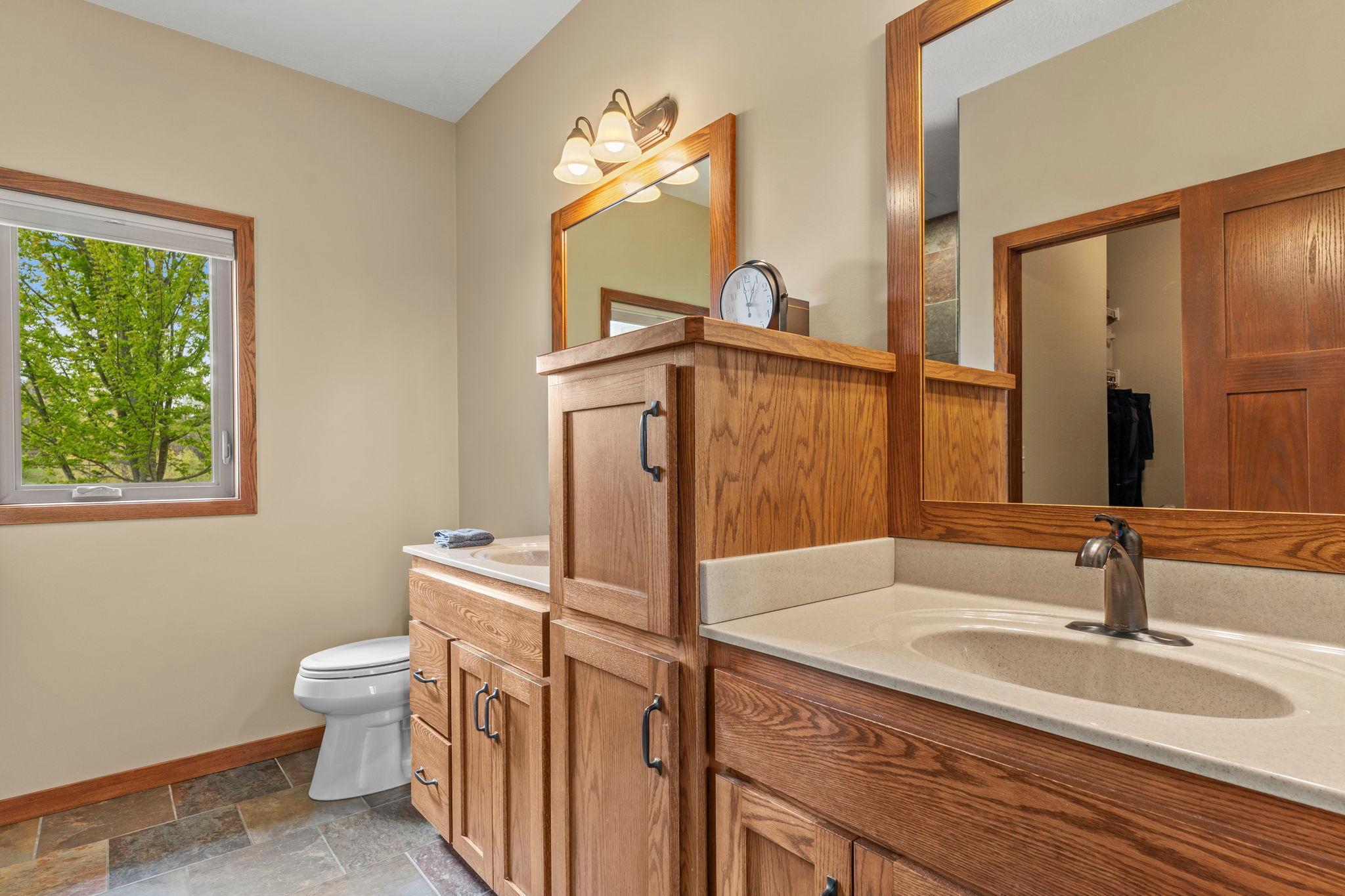Double vanity, plenty of cabinet space and tile floors in the primary bathroom