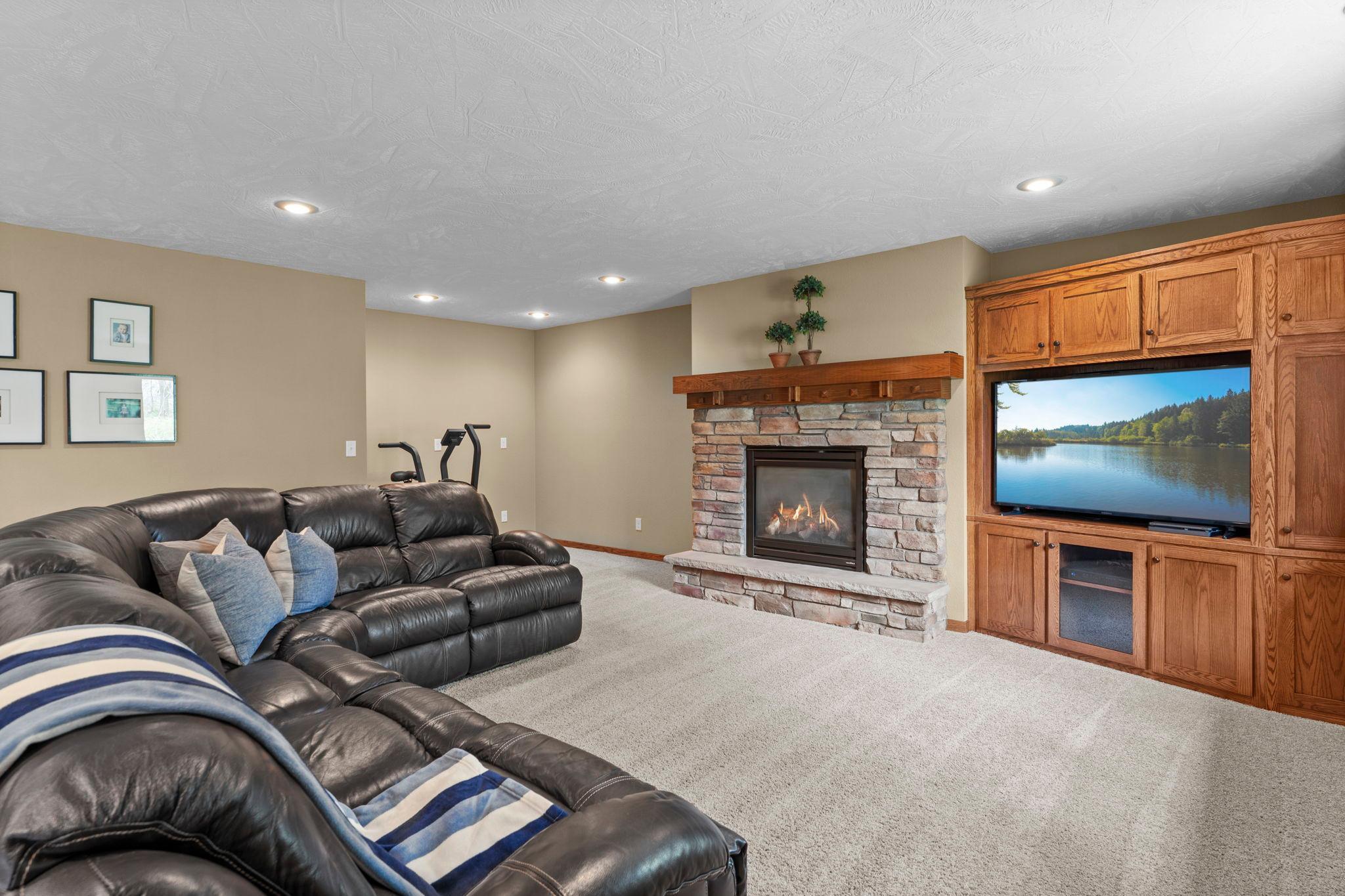 Cozy family room accented by a fireplace and built-ins, along with heated floors throughout the lower level