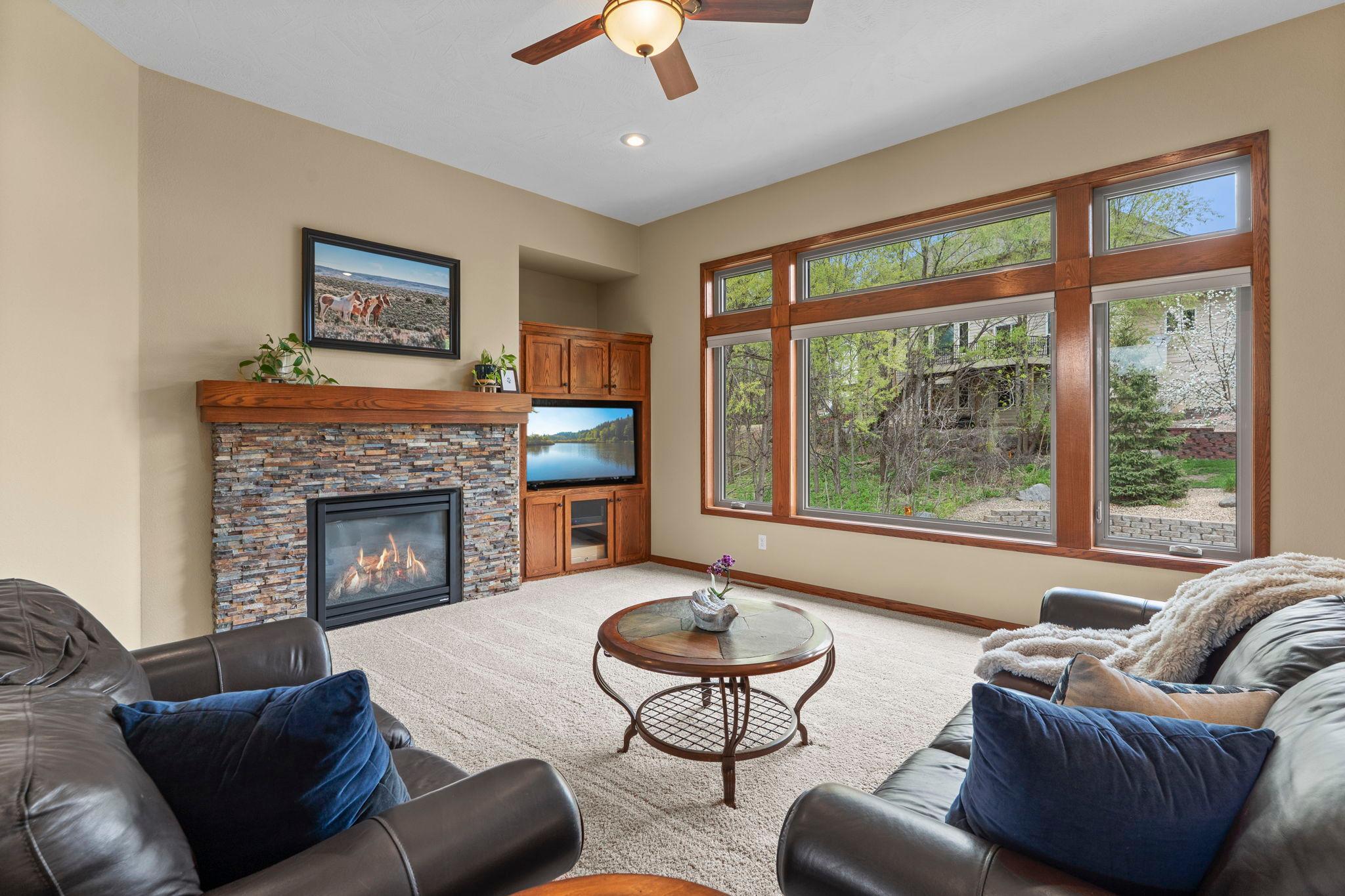 Cozy living room centered around the fireplace and includes a built-in entertainment center
