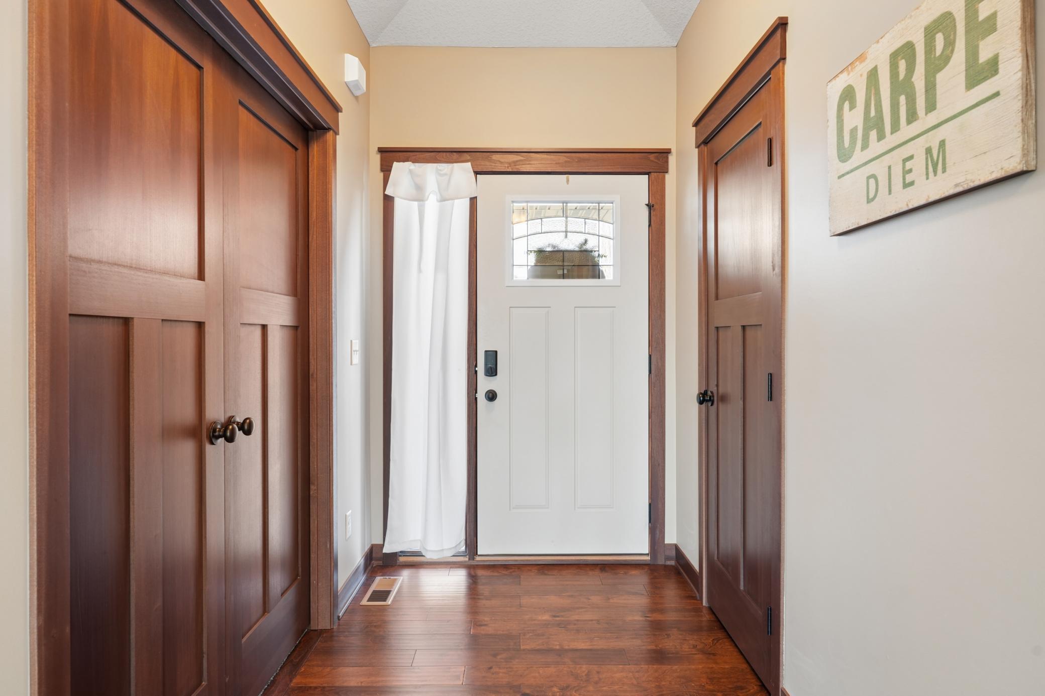 Step into a welcoming foyer finished with rich wood flooring and warm millwork