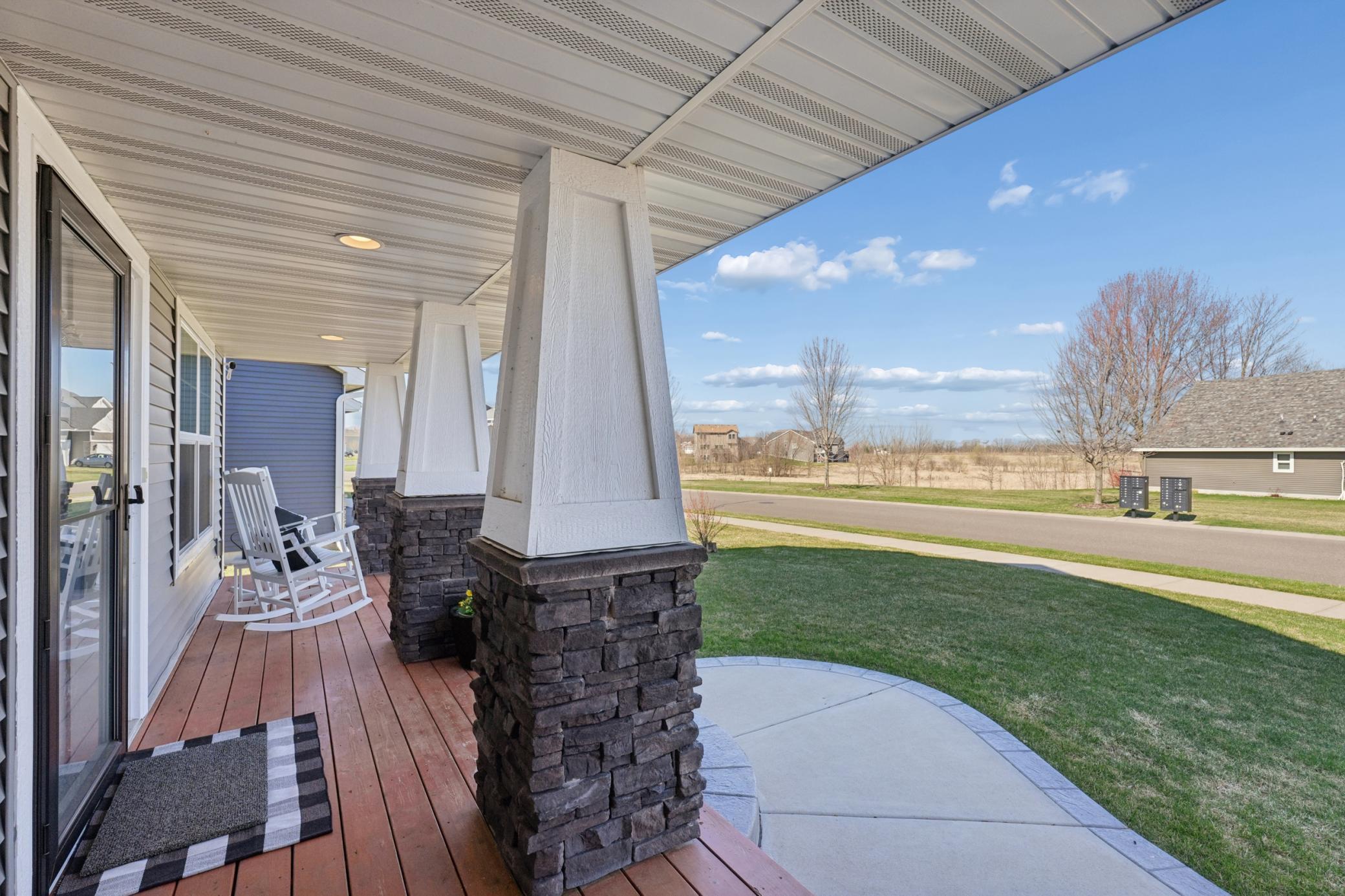 The charming covered front porch with stone columns is the perfect spot for morning coffee or evening conversation