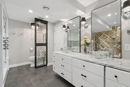 This bathroom couldn't be more luxurious - with glass bowl sinks,gorgeous countertops, & the perfect set of mirrors.