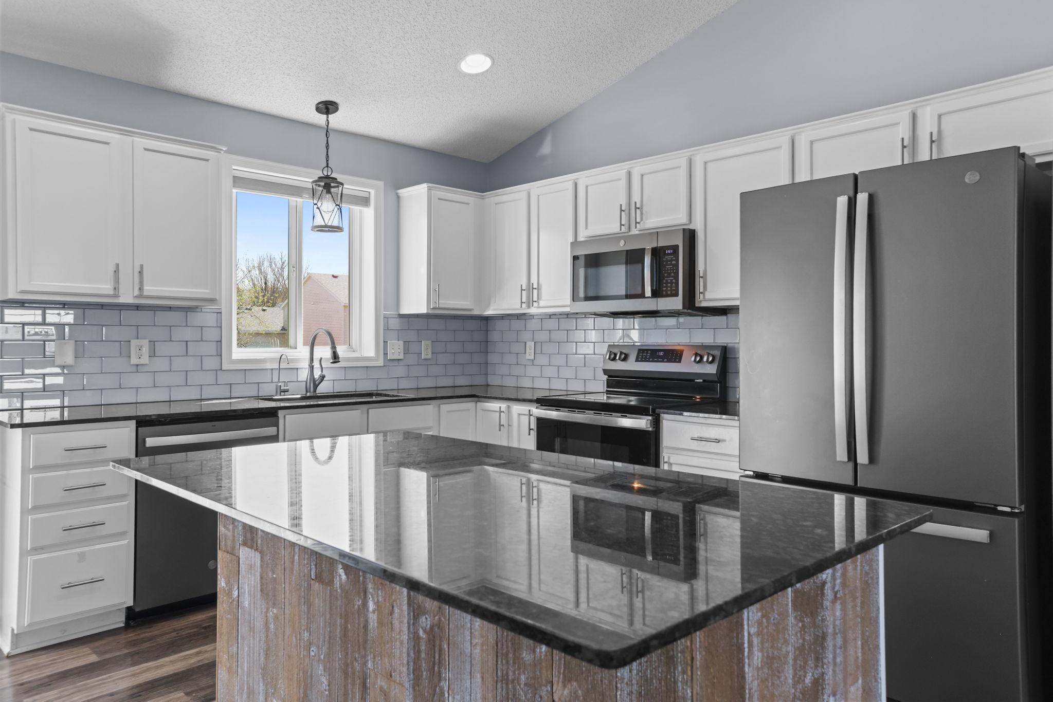 White Enameled Cabinets, Smudge Proof Stainless Steel Appliances, Subway Tile Backsplash and Granite Countertops.