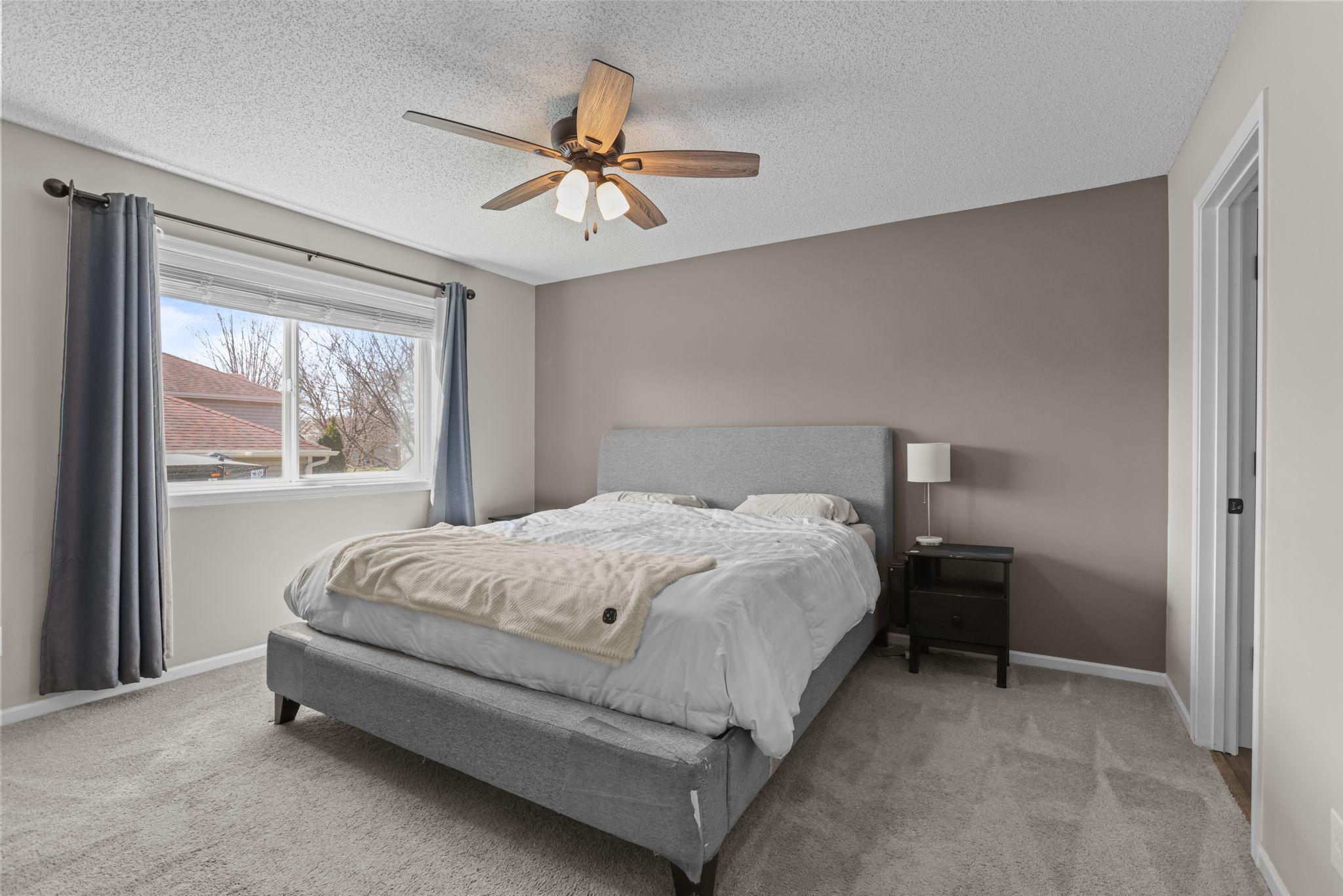 Primary Bedroom with ensuite, fan and walk-in closet.