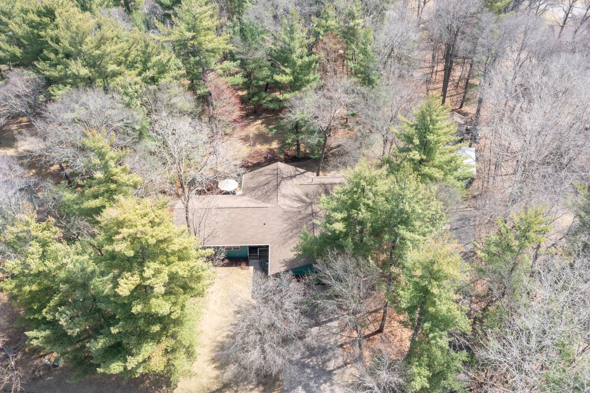Aerial view showcasing the home’s private setting surrounded by mature trees, offering both shade and seclusion.