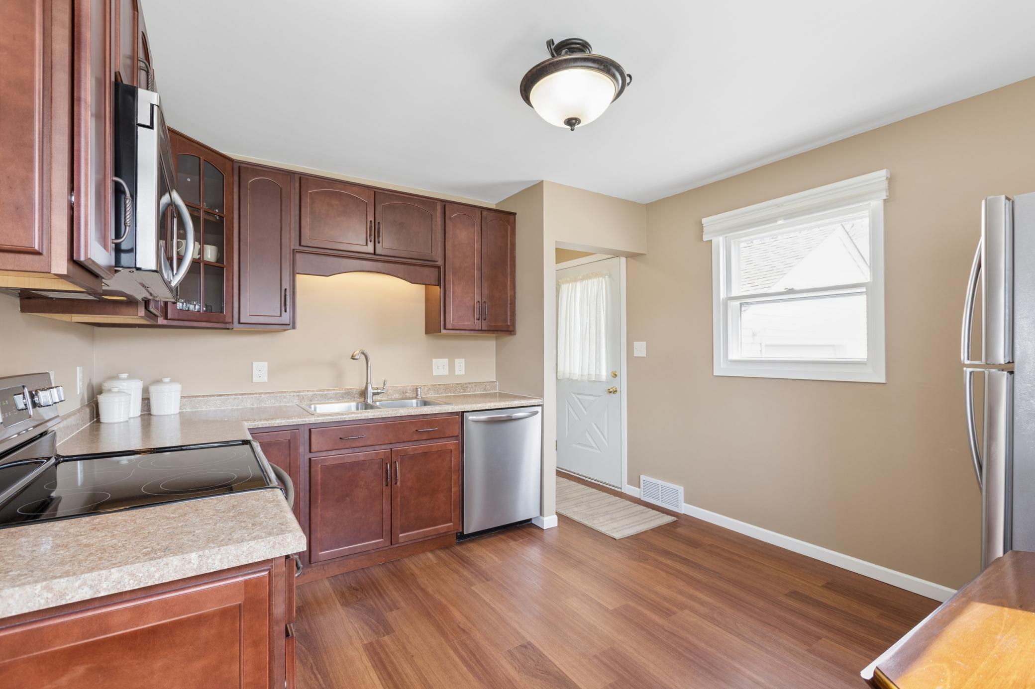 The kitchen features S.S. appliances, a garbage disposal, and beautifully stained wood cabinets.