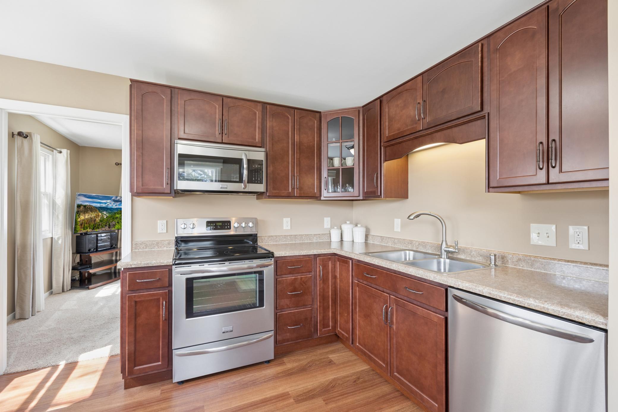 The kitchen features beautifully stained wood cabinets and stainless steel Frigidaire Gallery appliances.