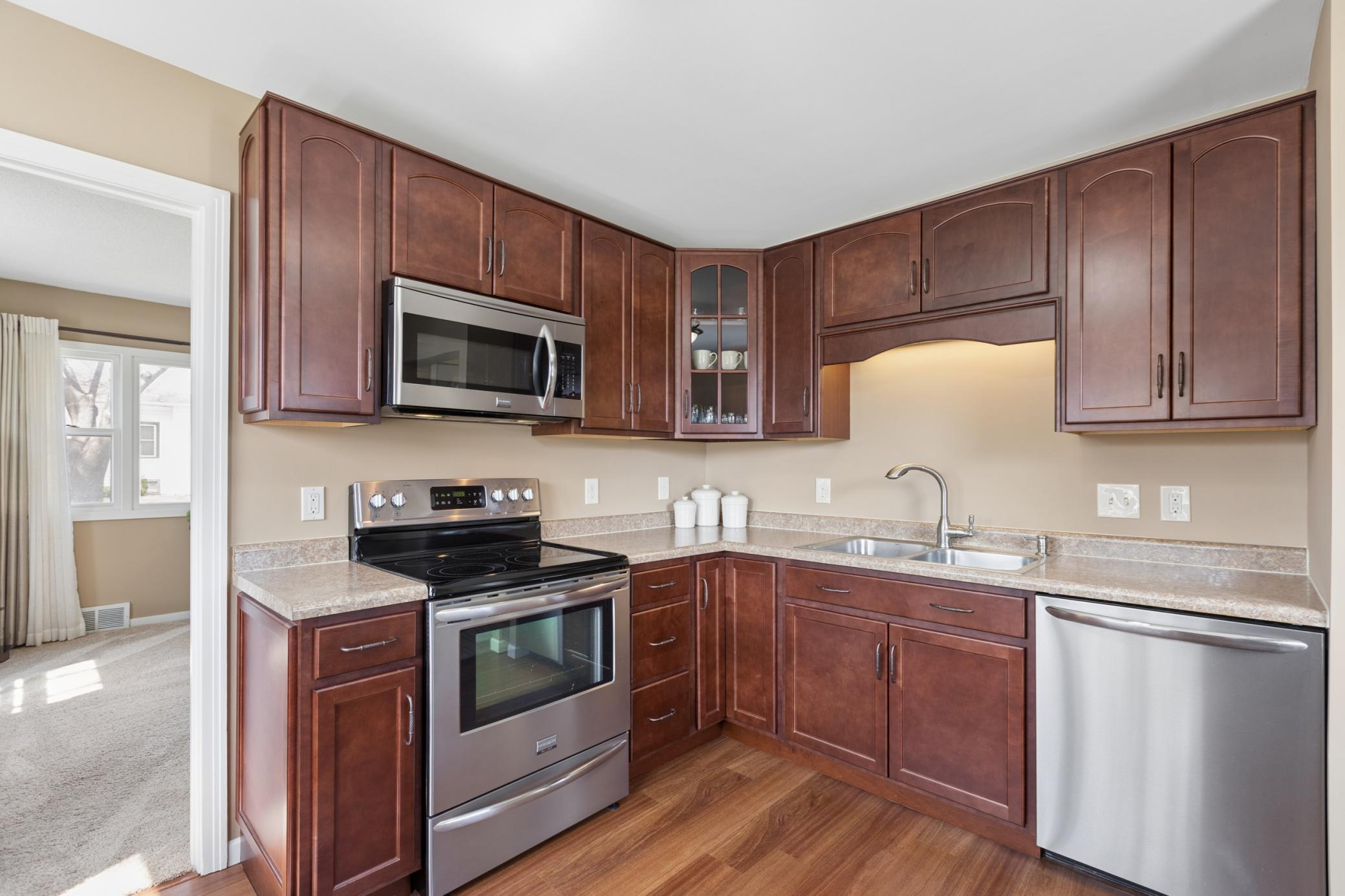 The kitchen features S.S. appliances, a garbage disposal, and beautifully stained wood cabinets. Durable LVP flooring is featured in the kitchen.