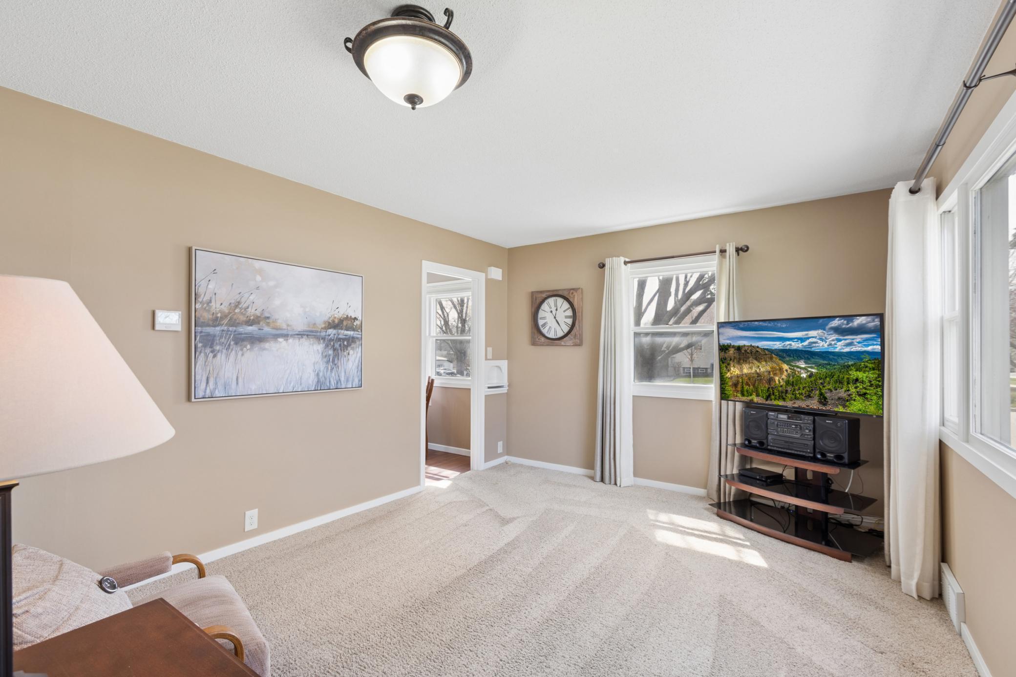 Natural light floods the spacious living room through a large picture window.