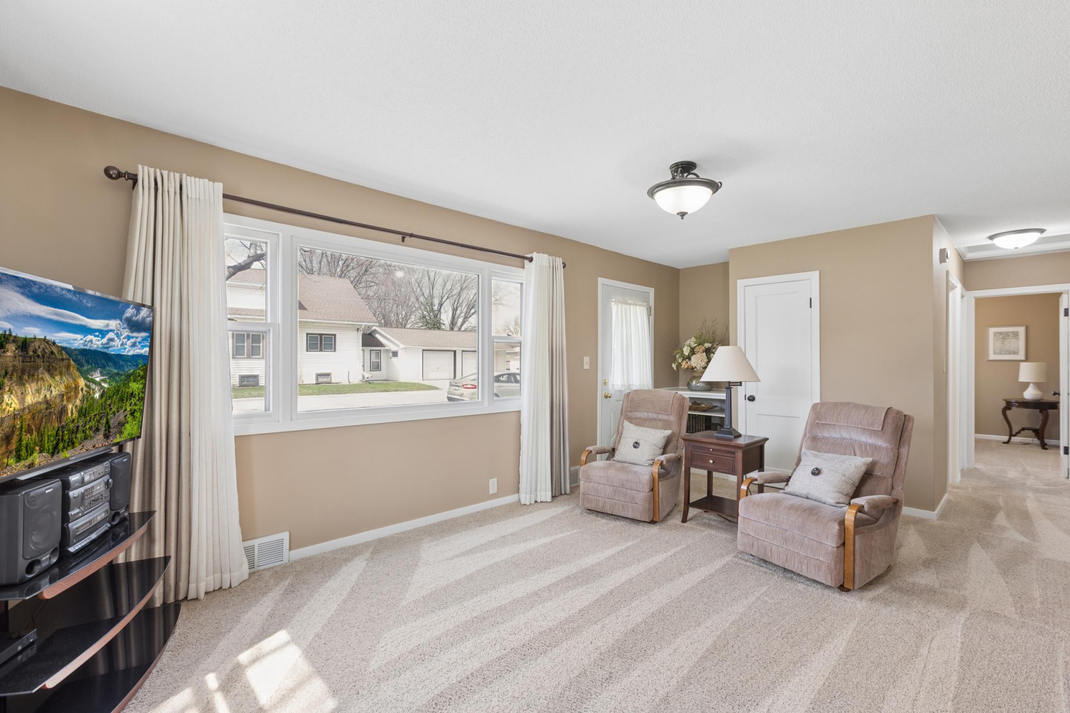 Natural light floods the spacious living room through a large picture window.
