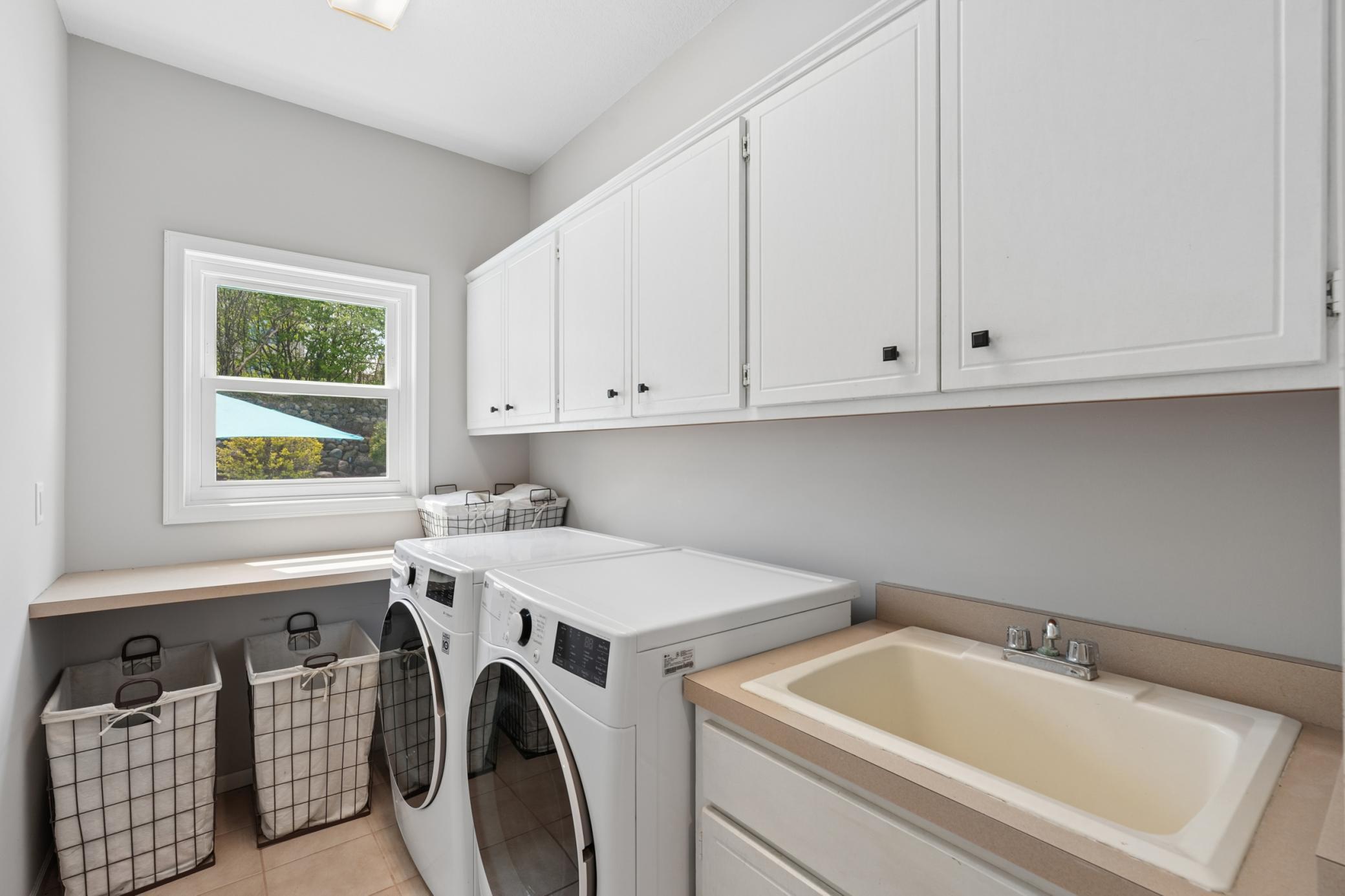 Main floor laundry with sink & storage!