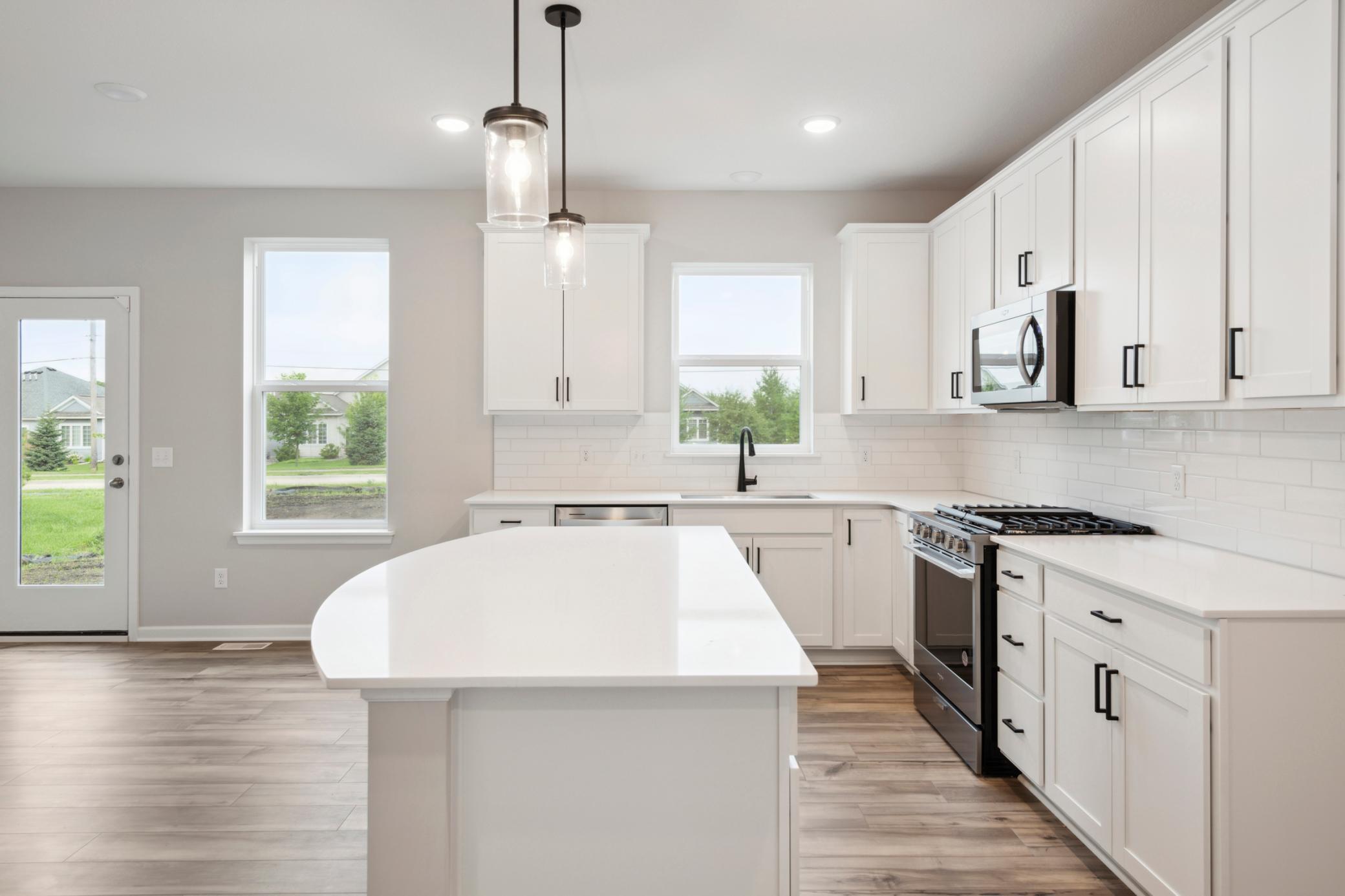 Curved center island with quartz countertops
