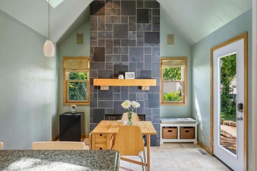 The dining area's two-story slate fireplace is the heart of the home â flanked by windows, flooded with light, and opening directly to the back deck.