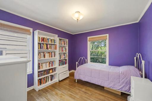 A cheerful main floor bedroom with hardwood floors, crown molding, and great natural light â ready to make your own.