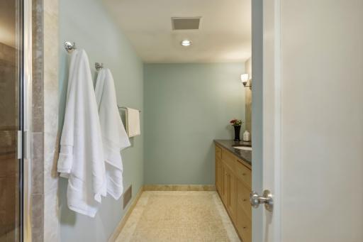 A spa-like ensuite with a custom-tiled steam shower, granite vanity, tile floors, and serene sage tones â your own private retreat.