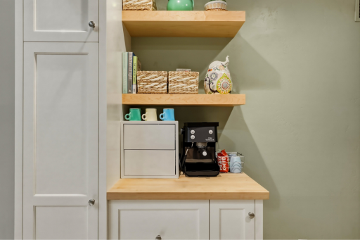 Built-in coffee bar nook with butcher block countertop, floating shelves, and valuable cabinet storage.