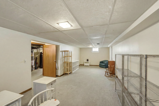 Another angle of the generous lower level with plenty of room to spread out â digitally edited to remove storage boxes to showcase what you can create â a workshop, rec room, or play zone.