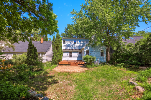 The backyard has a wood deck, paver patio, and mature landscaping with enough room for play, entertaining, and relaxation.