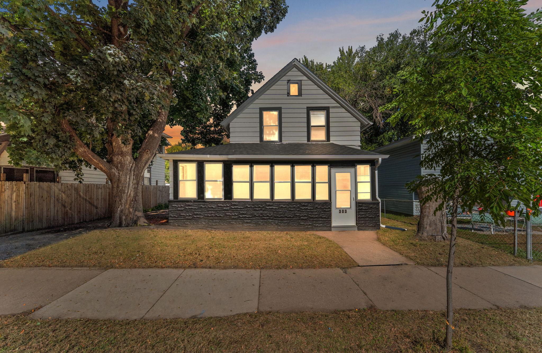 Front porch with wall to wall windows across a tree lined street for privacy and comfort