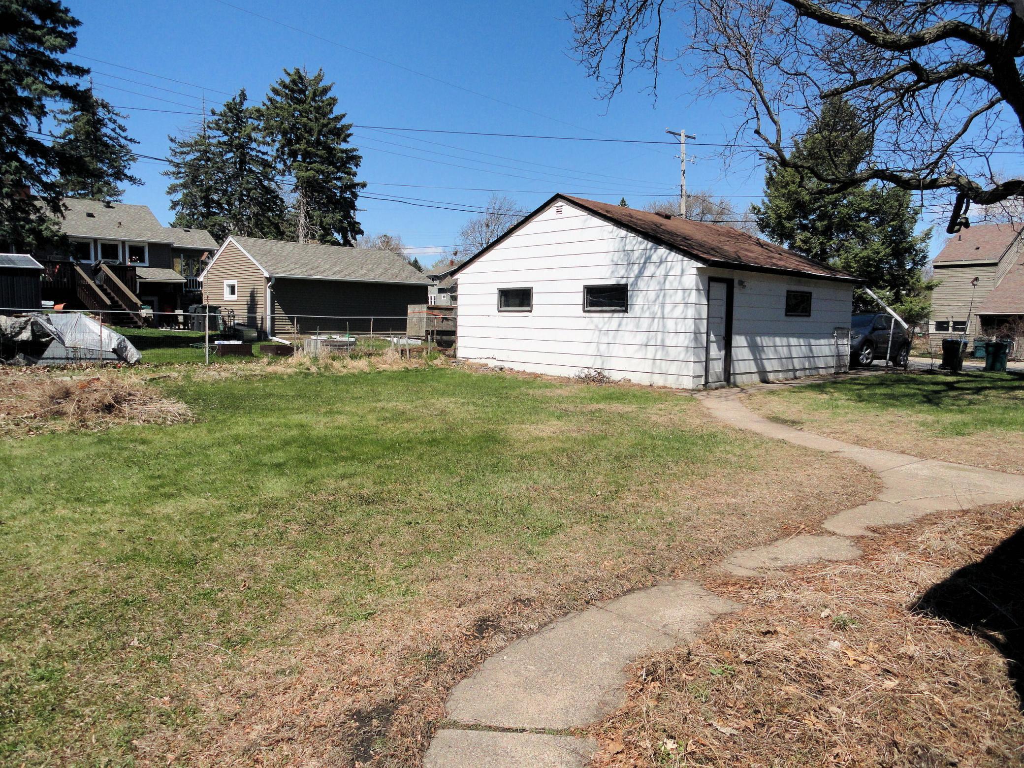 This view across the level backyard to the 2 car garage. Play & romp, garden & grow.
