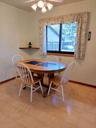 Informal dining with easy access to the kitchen for an extra serving or a beverage. Overhead a ceiling fan with lights adds to your comfort. From the window, views of the backyard & 3 season porch.