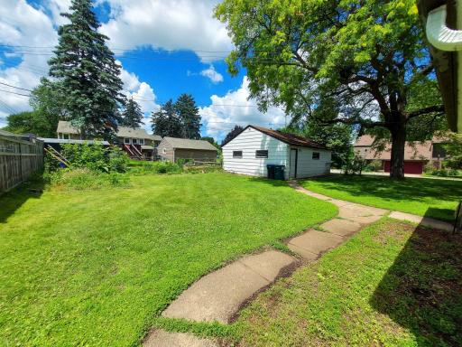 Large level backyard with walkway from front door to 3 season porch & 2 car garage.