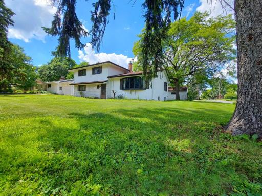 Evergreen trees add constant color to this front yard & attract nesting song birds too. Large corner lot gives you extra green space & a shorter driveway so snow removal is easier.