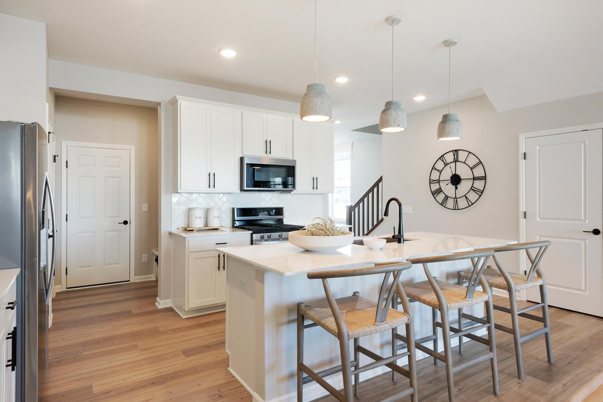 The Ashton also features modern white cabinets that complement the stainless-steel appliances perfectly! Photo of model home.