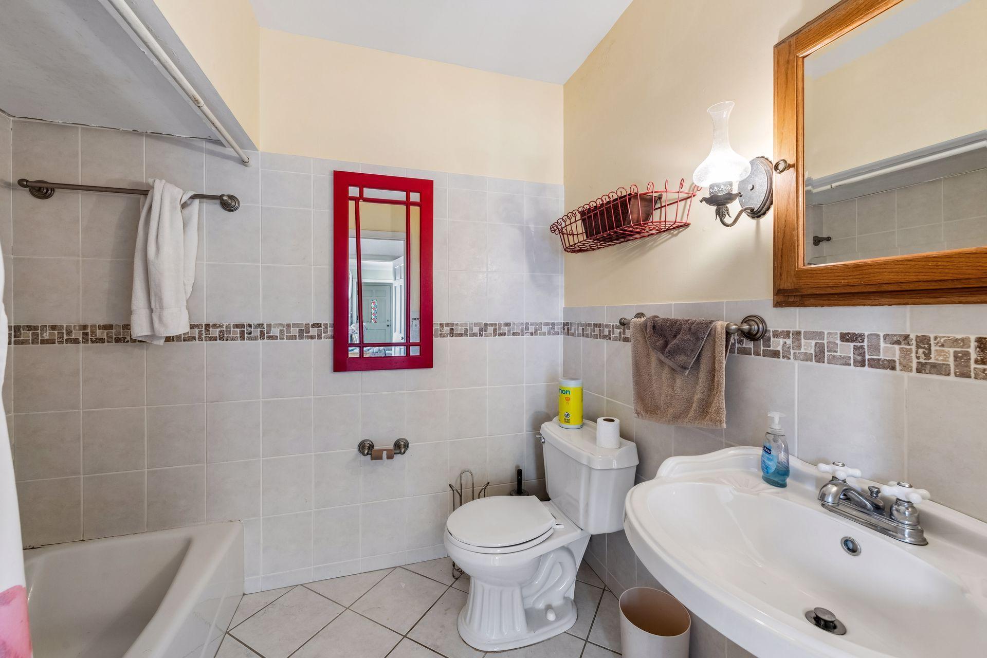 The main level full bath is accentuated with tile and a pedestal sink