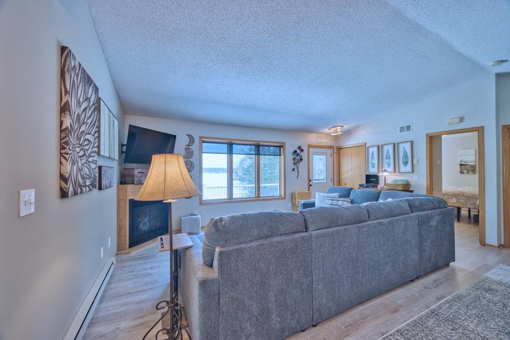 Living room with gas fireplace and lake view. All furniture is new as of September 2024.