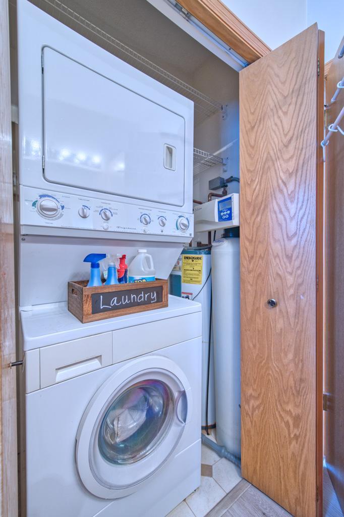 Laundry closet with water heater and softener.