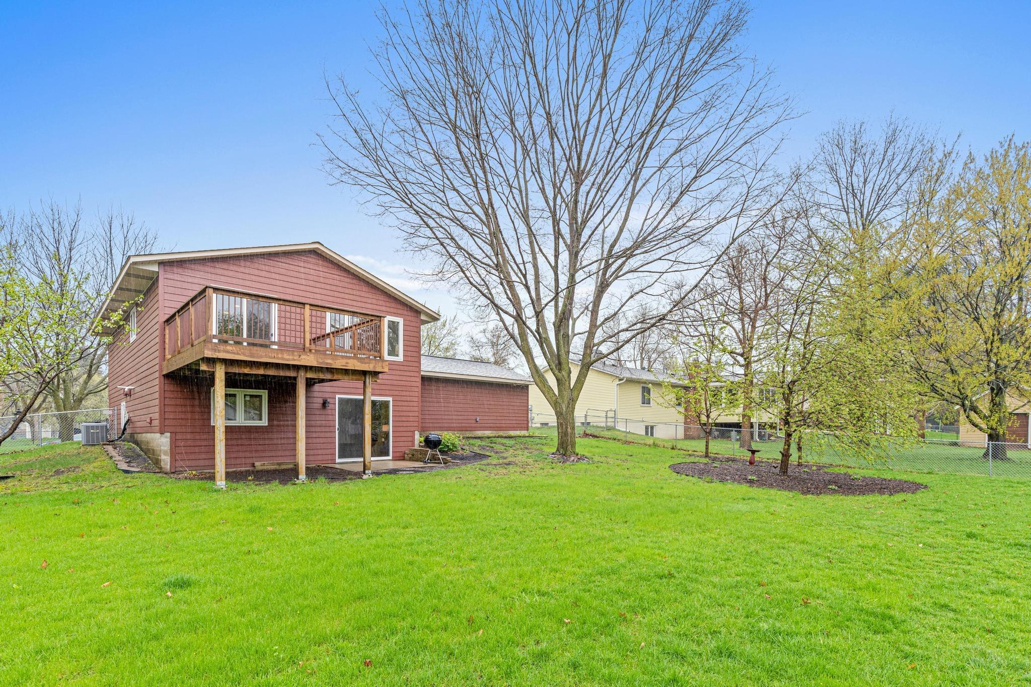 Expansive, fully fenced backyard with mature trees.